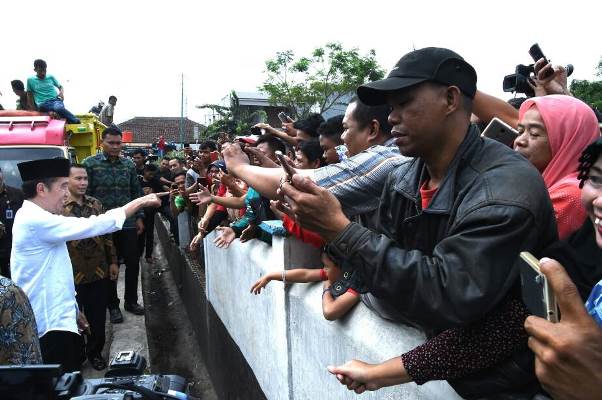 Presiden Joko Widodo berkesempatan bercanda dengan masyarakat di tengah-tengah pembagian sembako (Foto ISTIMEWA)
