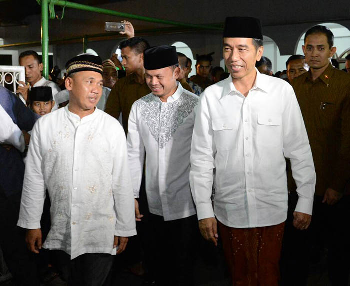 Presiden Joko Widodo didampingi Walikota Bogor Arya Bima Sugiarto (tengah) dan Komandan Paspampres Mayjen TNI (Mar) Suhartono  bersiap meninggalkan masjid selepas menunaikan shalat Tarawih.