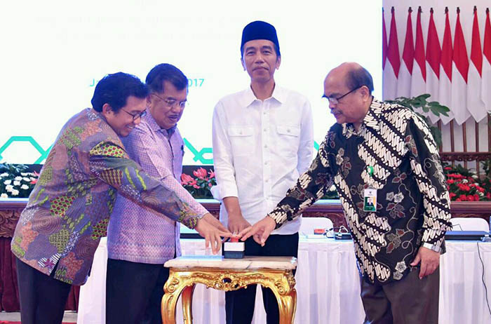 Presiden Joko Widodo dan Wakil Presiden Jusuf Kalla menyalurkan zakat mereka didampingi Ketua BAZNAS Bambang Sudibyo (pojok kanan) meluncurkan program penghimpunan zakat melalui agen Laku Pandai .