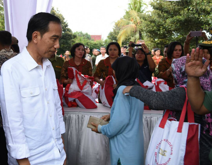 Presiden Joko Widodo menyaksikan langsung pembagian paket sembako sambil menyapa masyarakat yang tengah antri.