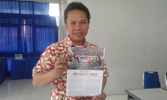 Ahmad Agus Setiawan, Ph. D. menunjukkan buletin Nawala karya bersama mahasiswa UGM (Foto R Toto Sugiharto/KAGAMA)
