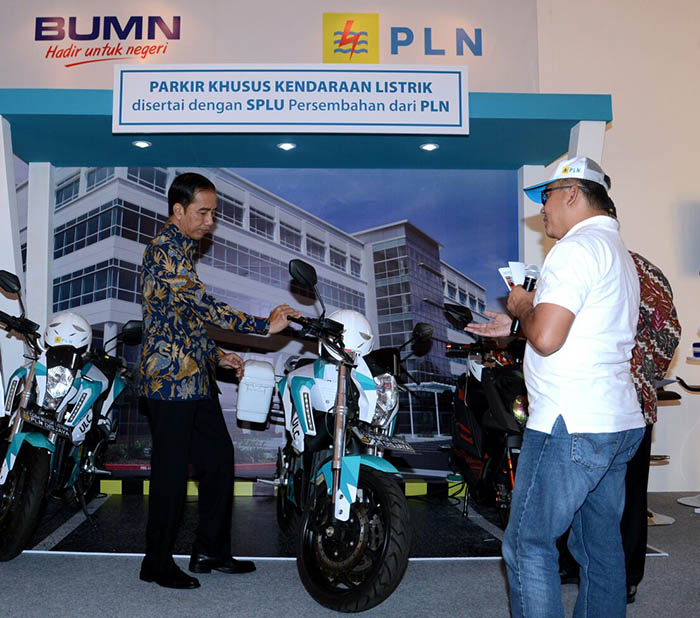 Presiden Joko Widodo teratrik dengan prototipe sepeda motor bertenaga listrik yang ikut dipamerkan.