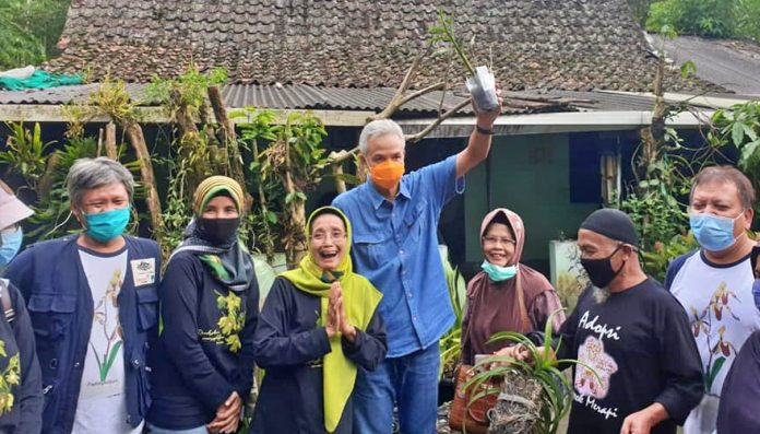Ketua Umum PP KAGAMA, Ganjar Pranowo menyerahka anggrek Vanda Tricolor sumbangan Kagama Orchids Kepada Musimin. Foto: Dok. KO